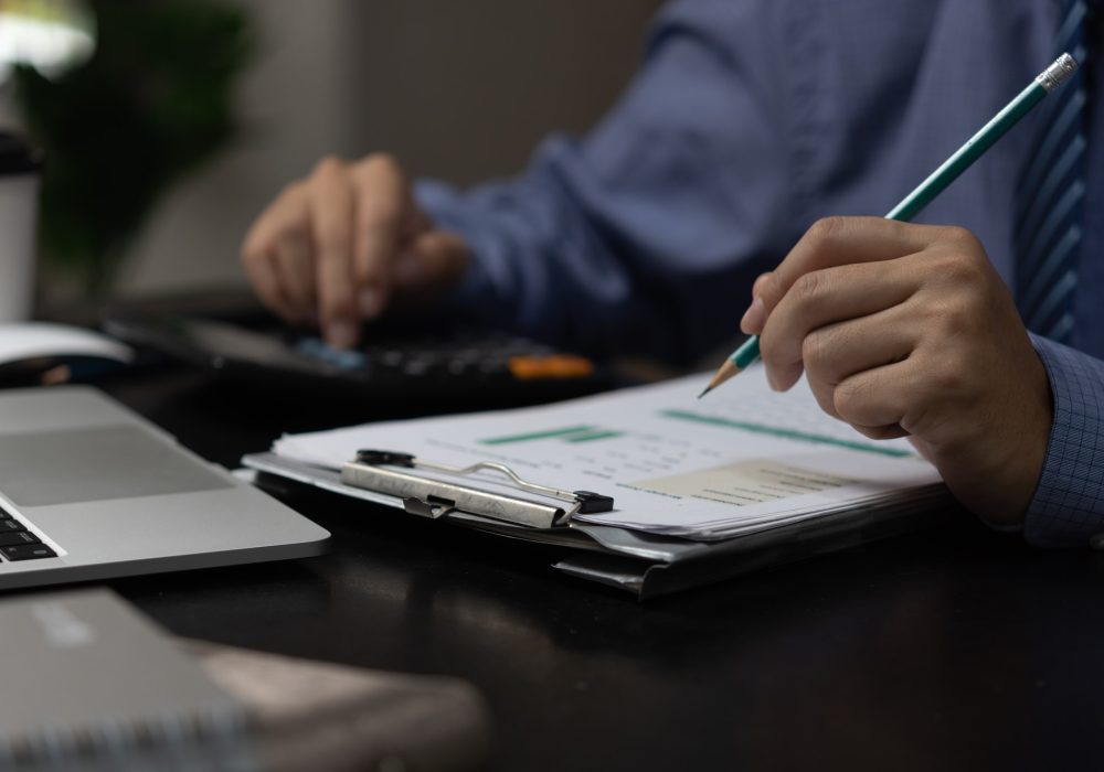 Businessman analyze marketing plan investment graph and financial chart growth management on desk.